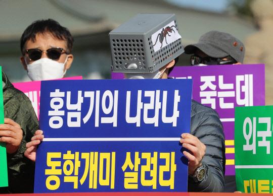 한국주식투자연합회 회원들이 지난 23일 오후 청와대 분수대 앞에서 기자회견을 열고 대주주 양도소득세 기준을 현행 10억 원으로 유지할 것을 요구하고 있다. 연합뉴스